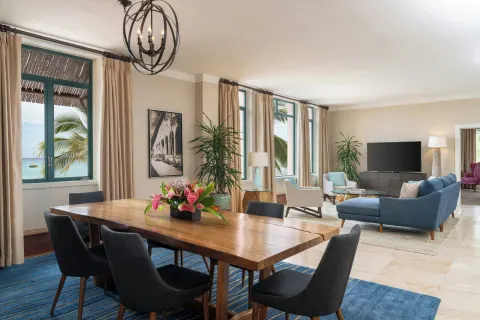 Suite living and dining area with ocean-facing windows at The Royal Hawaiian, Waikiki.
