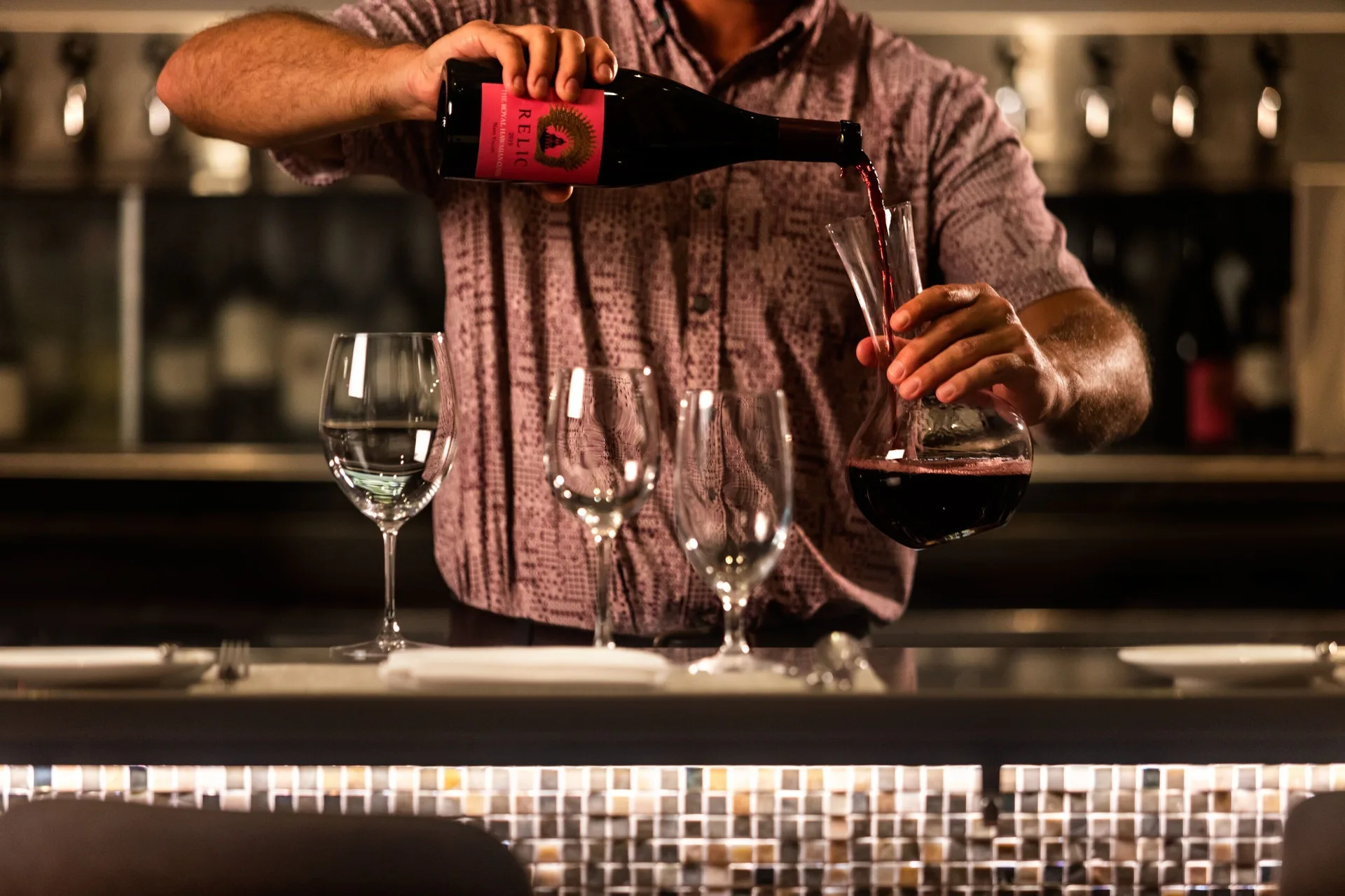 Server pouring red wine into a decanter at The Royal Hawaiian, Waikiki.
