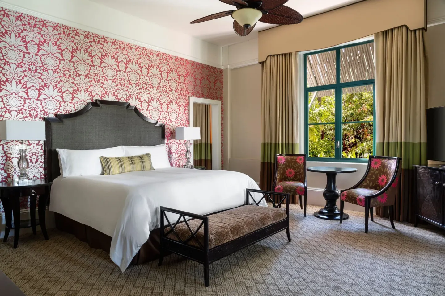 Historic Garden Jr. Suite king bed with seating by garden-view window at The Royal Hawaiian, Waikiki.