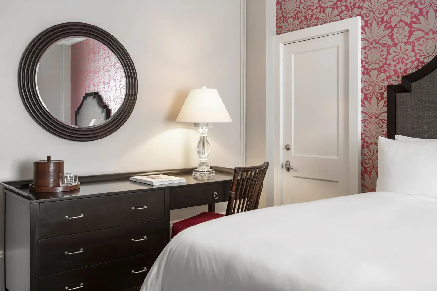 Desk, mirror, and bed in a Historic Room 1 at The Royal Hawaiian, Waikiki.