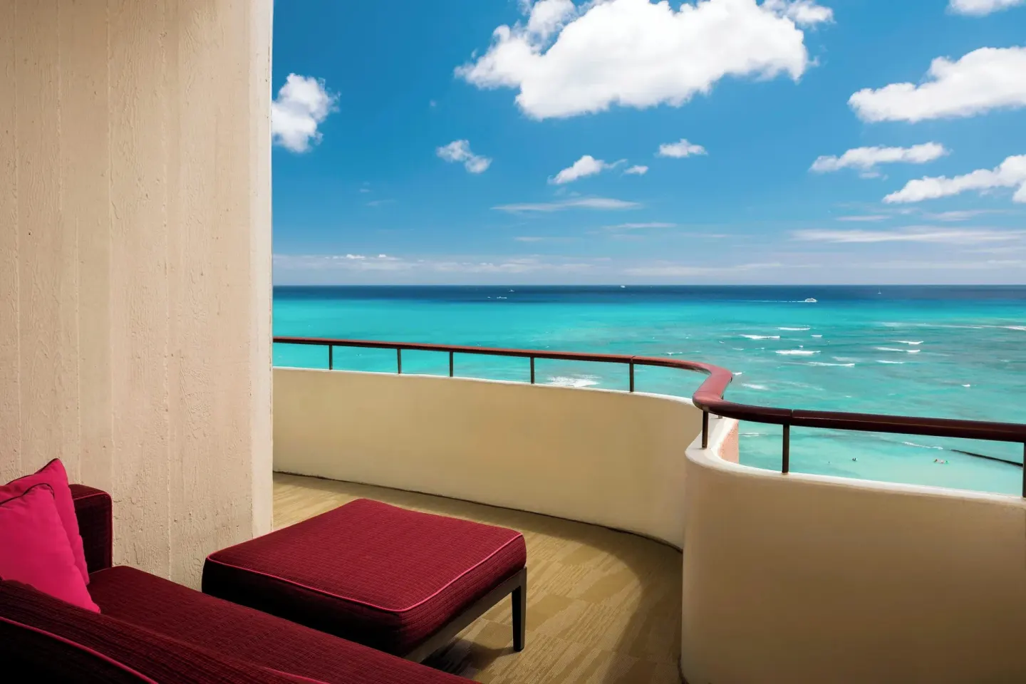Oceanfront balcony with red lounge seating at The Royal Hawaiian, Waikiki.