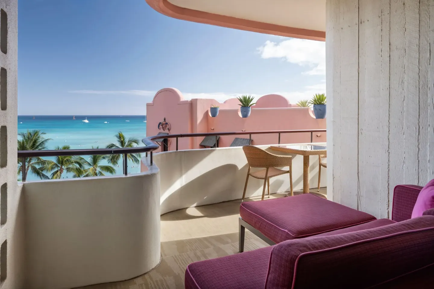 Oceanfront corner balcony with seating and ocean view at The Royal Hawaiian, Waikiki.