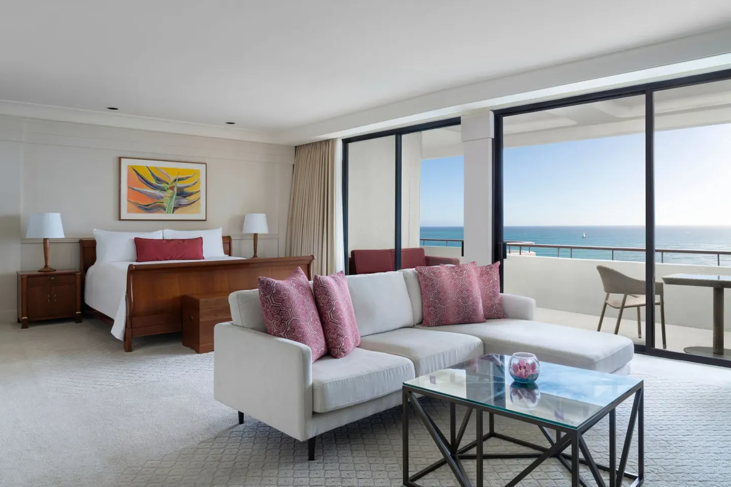 Prestige Suite king bed and sofa seating beside ocean-view balcony at The Royal Hawaiian, Waikiki.