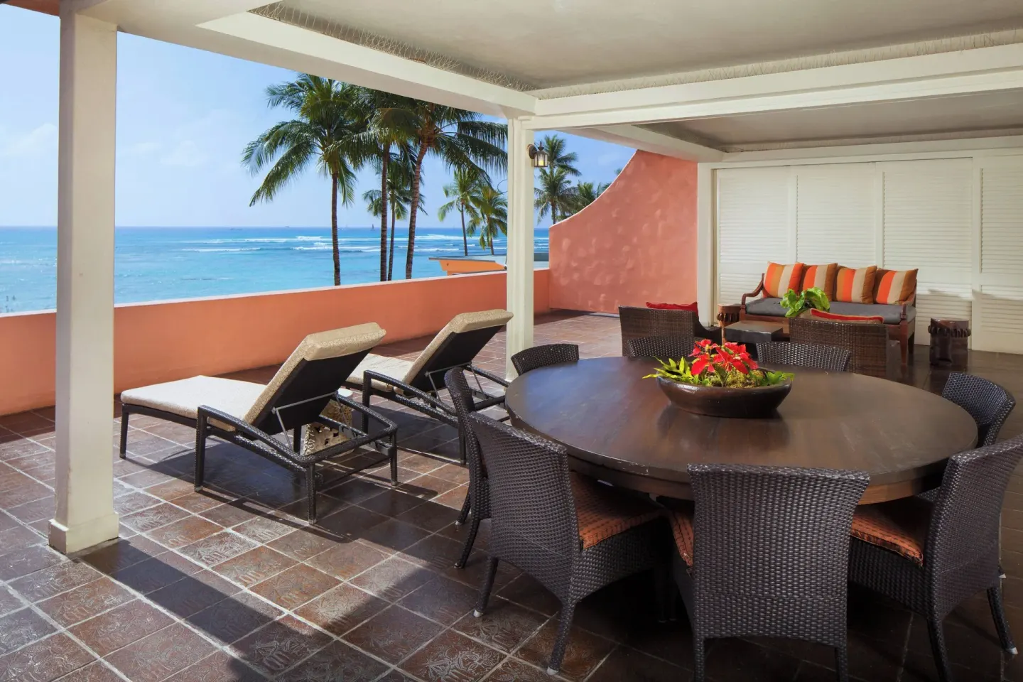 Prestige Suite oceanfront terrace with dining table and lounge chairs at The Royal Hawaiian, Waikiki.