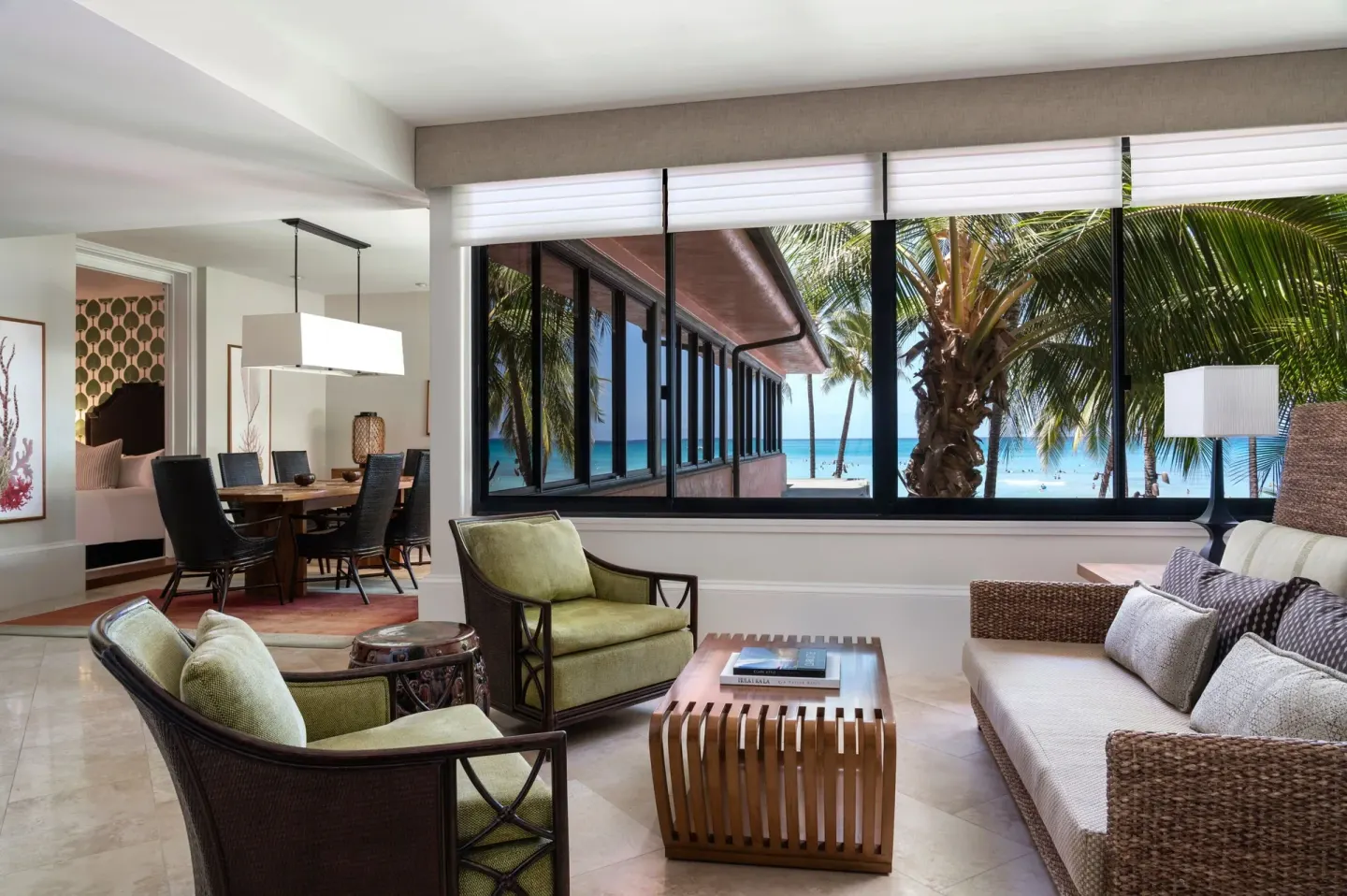 Prestige Suite sitting room with sofa, chairs, and palm-framed beach view at The Royal Hawaiian, Waikiki.