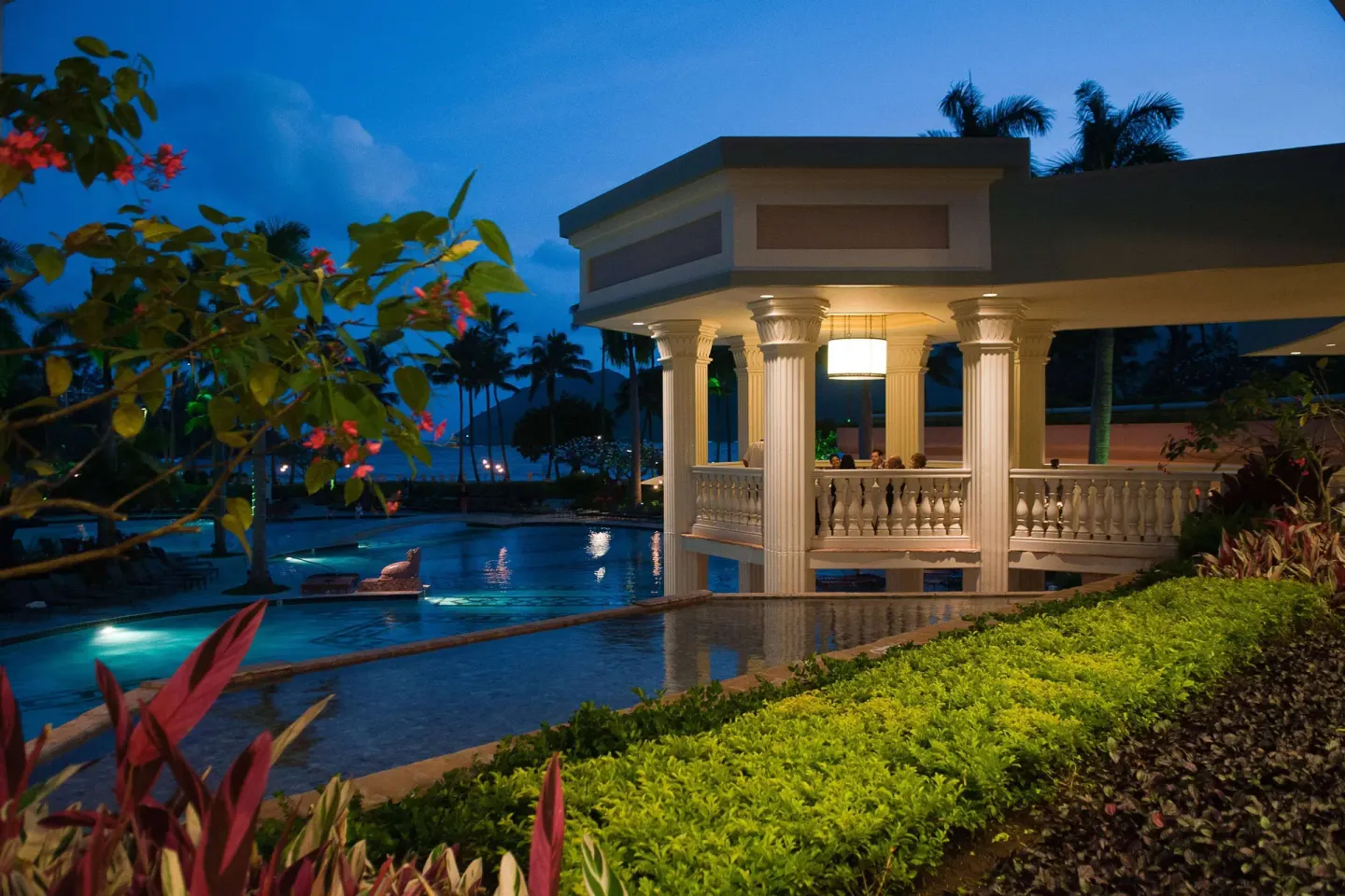 Evening poolside pavilion with columns and tropical plantings at The Royal Sonesta Kaua'i Resort Lihue.