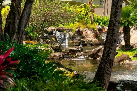 A landscaped waterfall flows through tropical gardens at The Royal Sonesta Kaua'i Resort Lihue.