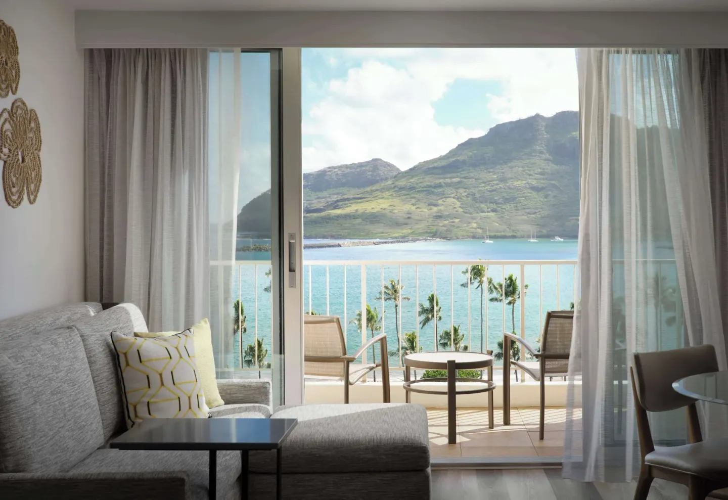 Guest room sitting area with balcony bay view at The Royal Sonesta Kaua'i Resort Lihue.