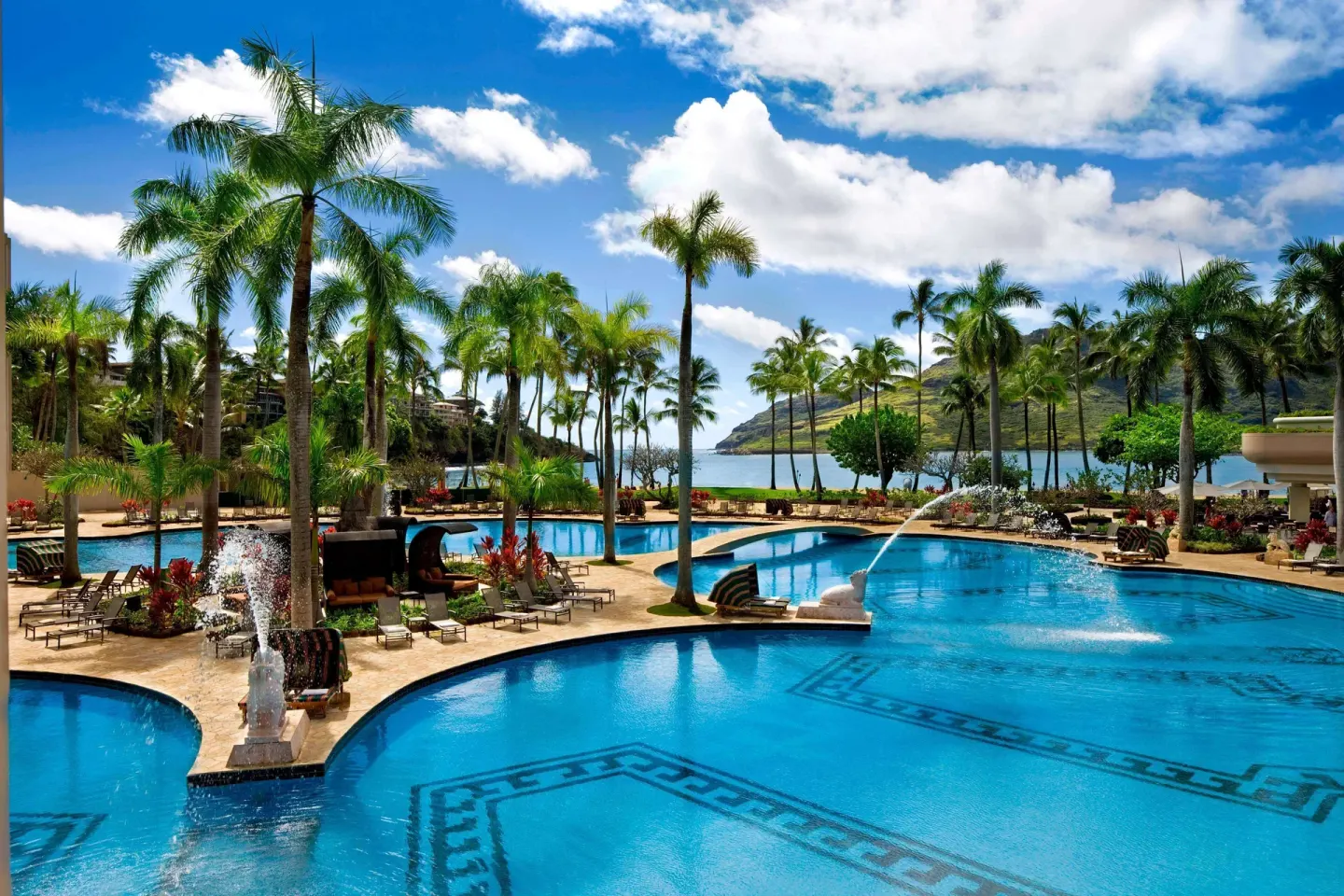 Palm-lined resort pool beside the bay at The Royal Sonesta Kaua'i Resort Lihue.