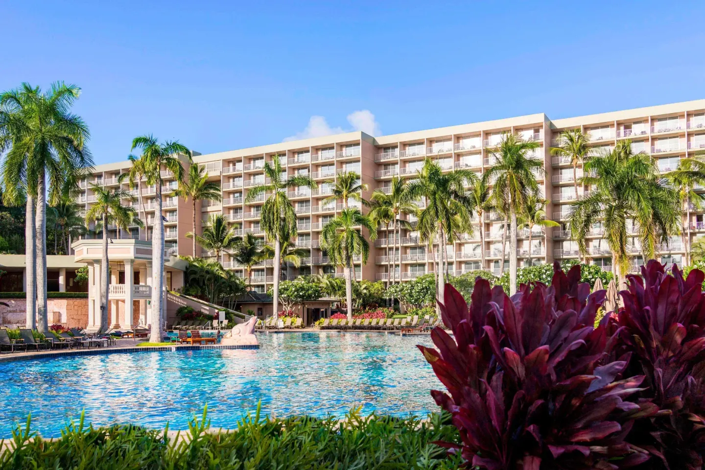 Large pool with palms and hotel balconies at The Royal Sonesta Kaua'i Resort Lihue.