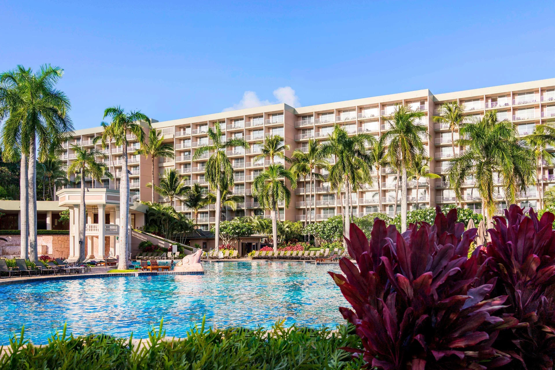 Large pool with palms and hotel balconies at The Royal Sonesta Kaua'i Resort Lihue.