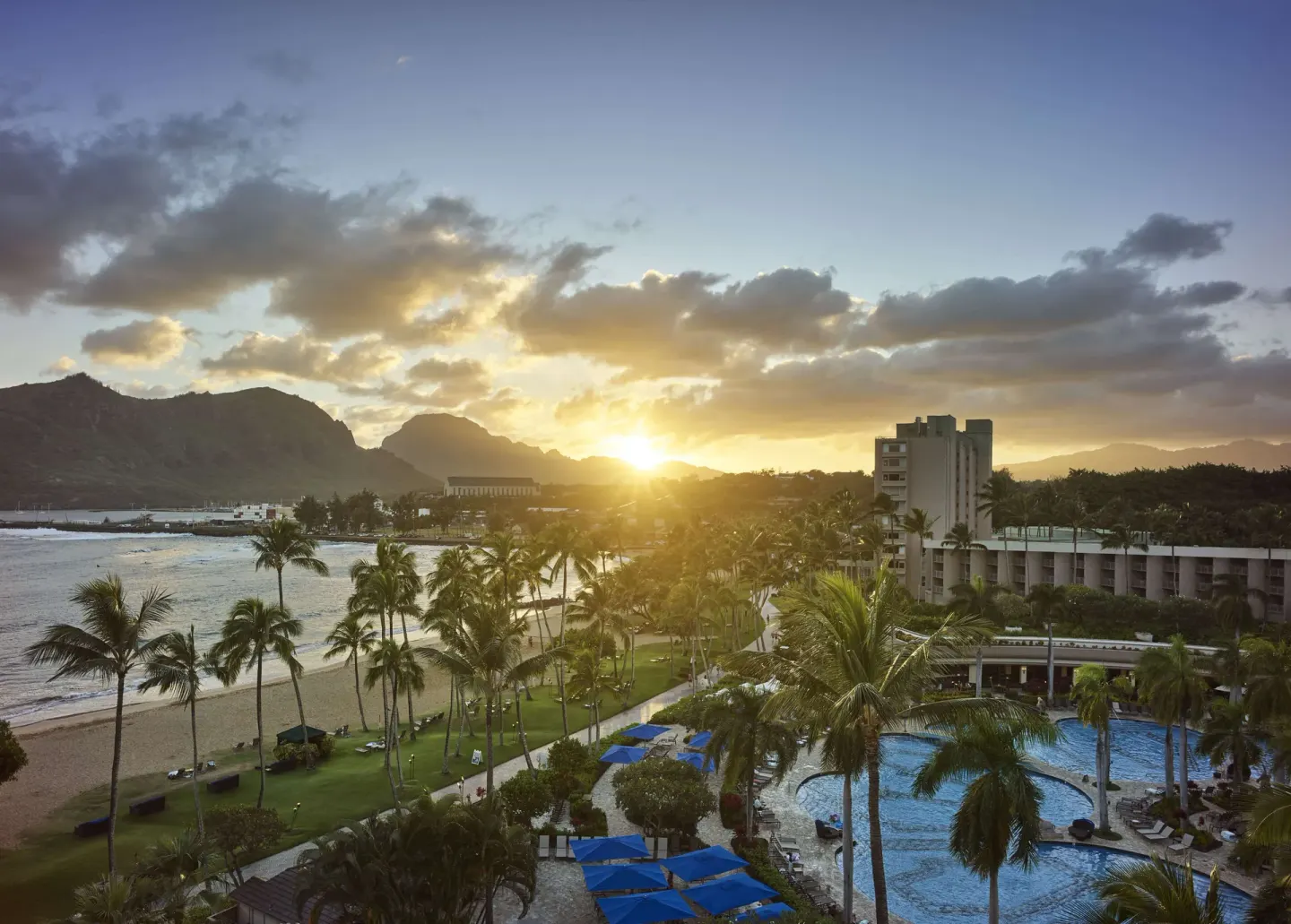 Sunset over the beach, pool, and palms at The Royal Sonesta Kaua'i Resort Lihue.