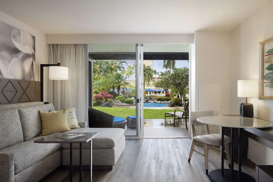 Sitting area and lanai doors in a Deluxe Ground Floor Lanai room at The Royal Sonesta Kaua'i Resort Lihue.