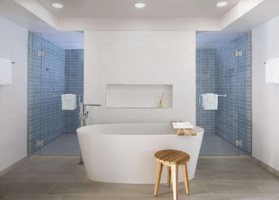 Oceanfront Presidential Suite bathroom at The Royal Sonesta Kaua'i Resort Lihue with tub and twin showers.