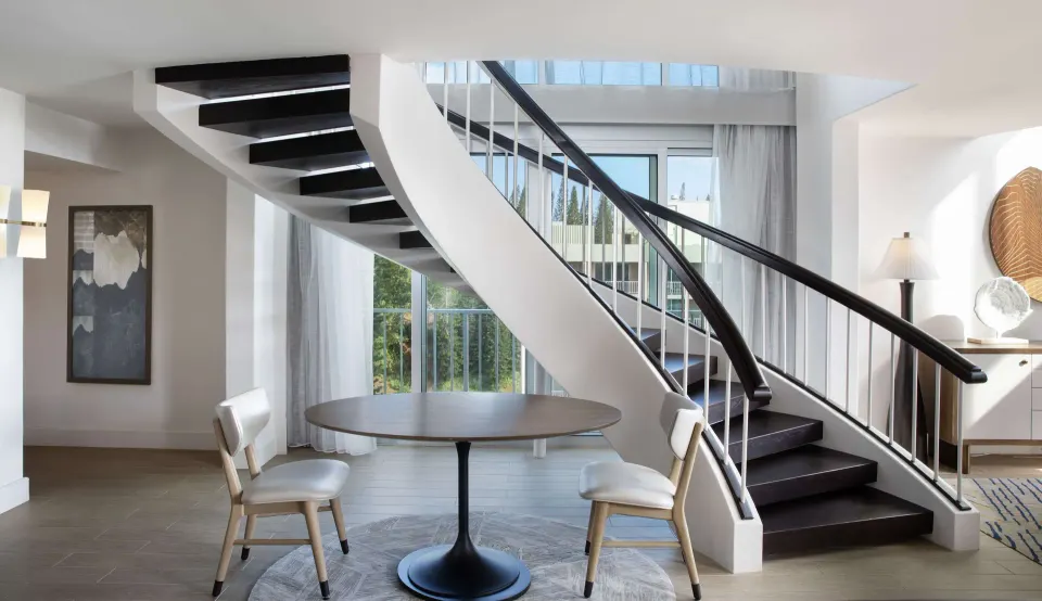 Oceanfront Presidential Suite staircase at The Royal Sonesta Kaua'i Resort Lihue beside a small table.