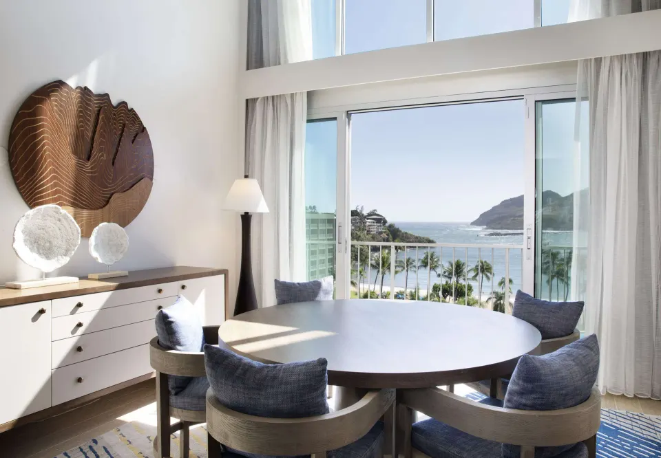 Oceanfront Presidential Suite dining table at The Royal Sonesta Kaua'i Resort Lihue with ocean-facing windows.