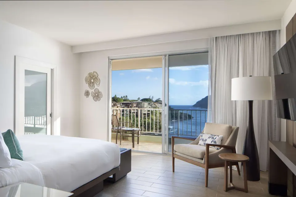 Oceanfront suite bedroom with balcony doors and water view at The Royal Sonesta Kaua'i Resort Lihue.