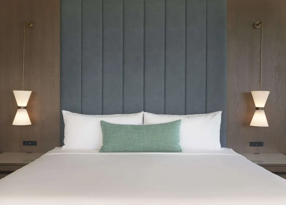 King bed with tall blue headboard in an oceanfront suite at The Royal Sonesta Kaua'i Resort Lihue.