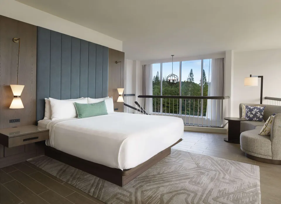 Oceanfront suite king bedroom with seating nook at The Royal Sonesta Kaua'i Resort Lihue.