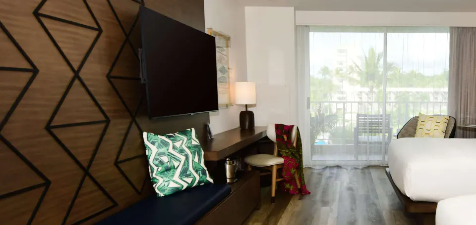 Desk, TV, bench, and balcony in a Two Queens room at The Royal Sonesta Kaua'i Resort Lihue.