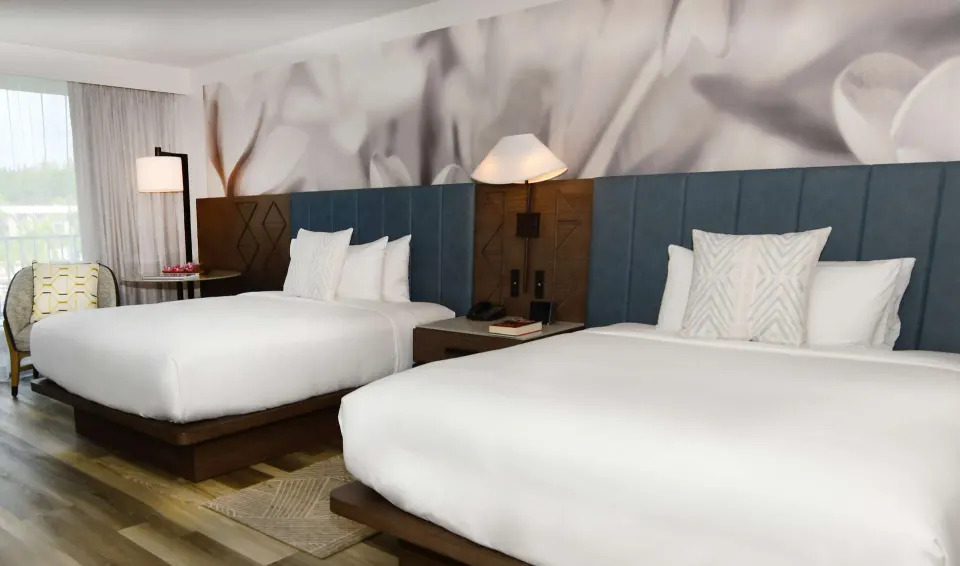 Two queen beds with mural wall art in a room at The Royal Sonesta Kaua'i Resort Lihue.