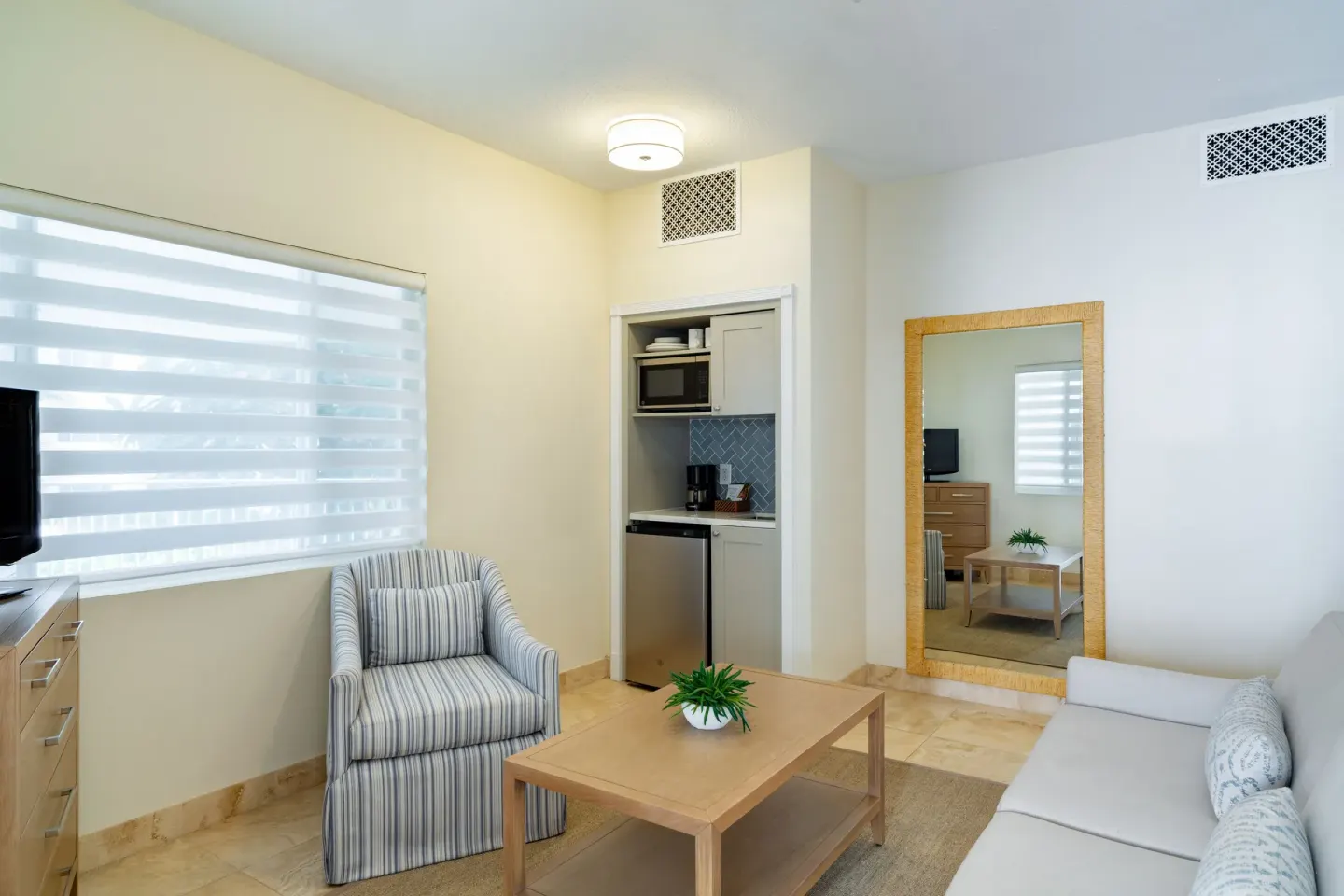 Living area with striped chair and kitchenette at The Sands at Grace Bay.