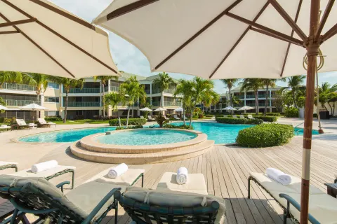 Pool loungers under umbrellas at The Sands at Grace Bay.