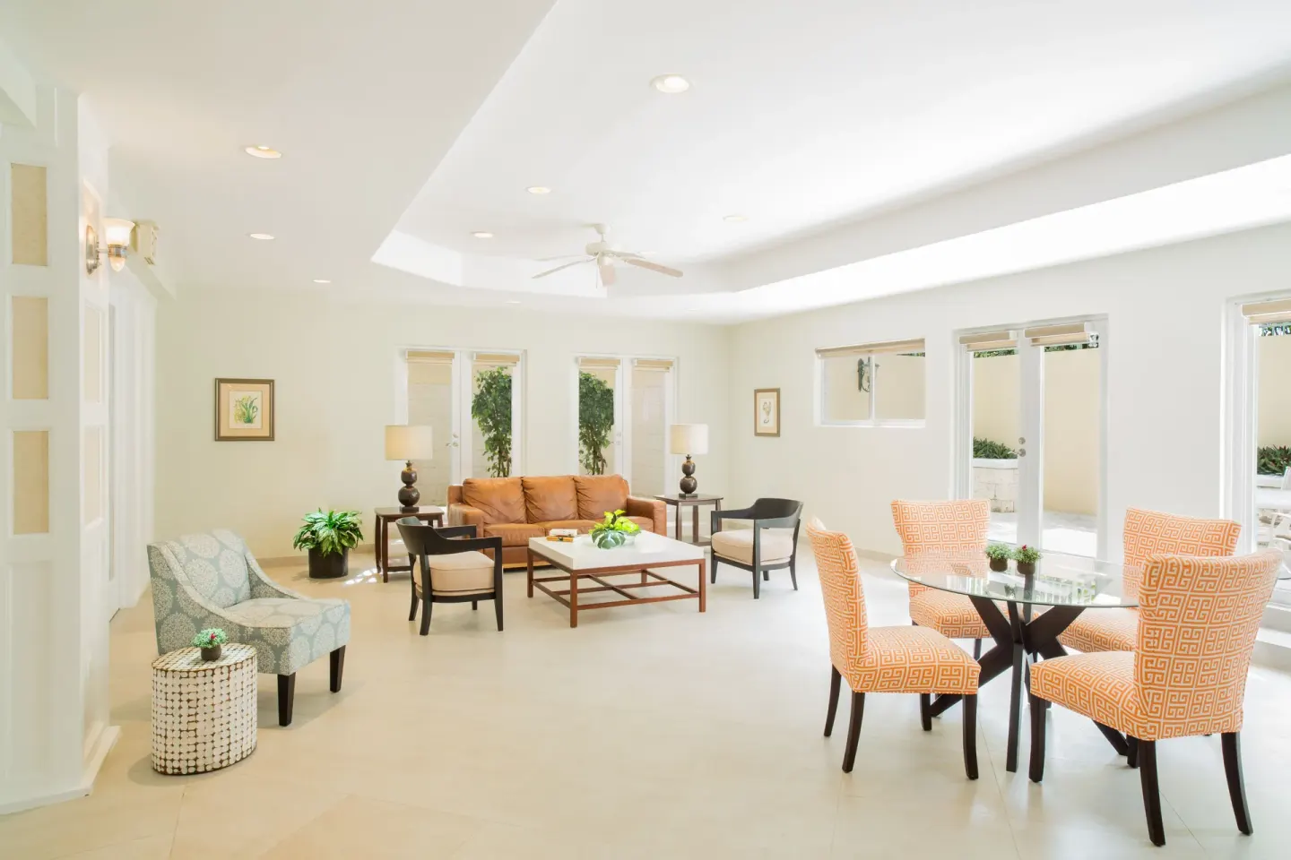 Bright resort lounge and dining area with sofas and orange chairs at The Sands at Grace Bay.
