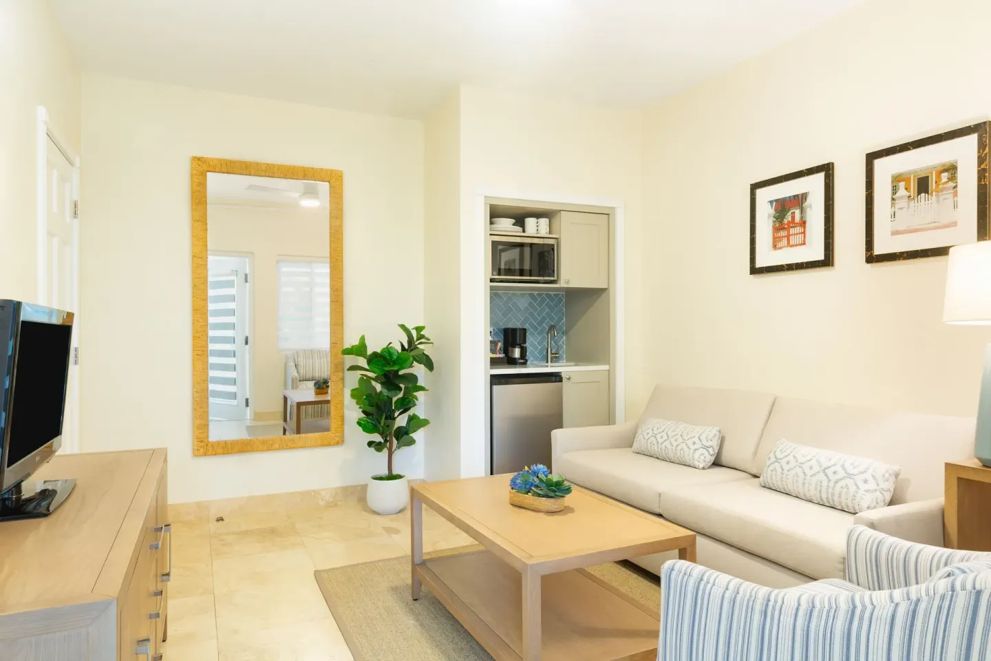 Suite living area with sofa and kitchenette at The Sands at Grace Bay.