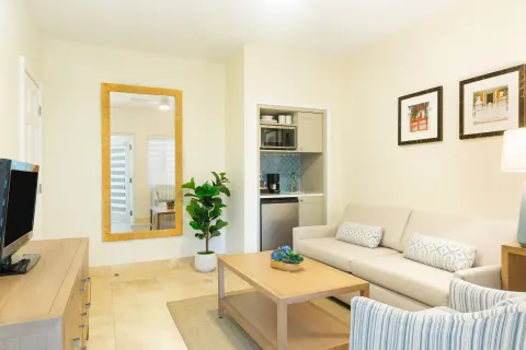 Suite living area with sofa and kitchenette at The Sands at Grace Bay.