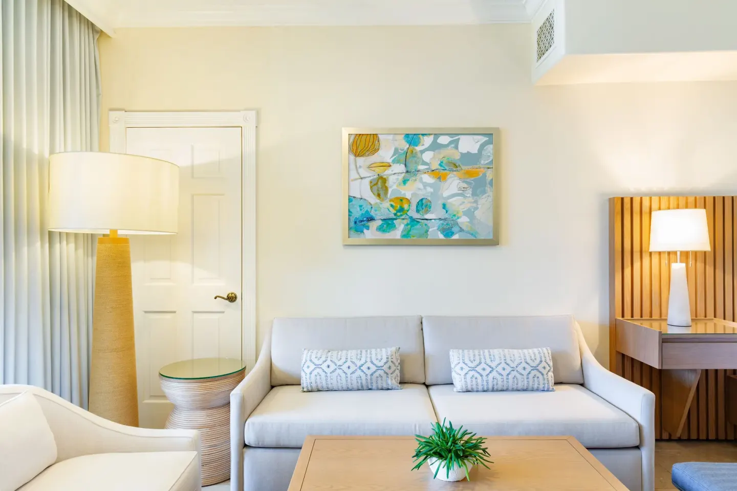 Junior Suite Garden View sitting area with sofa and table at The Sands at Grace Bay.