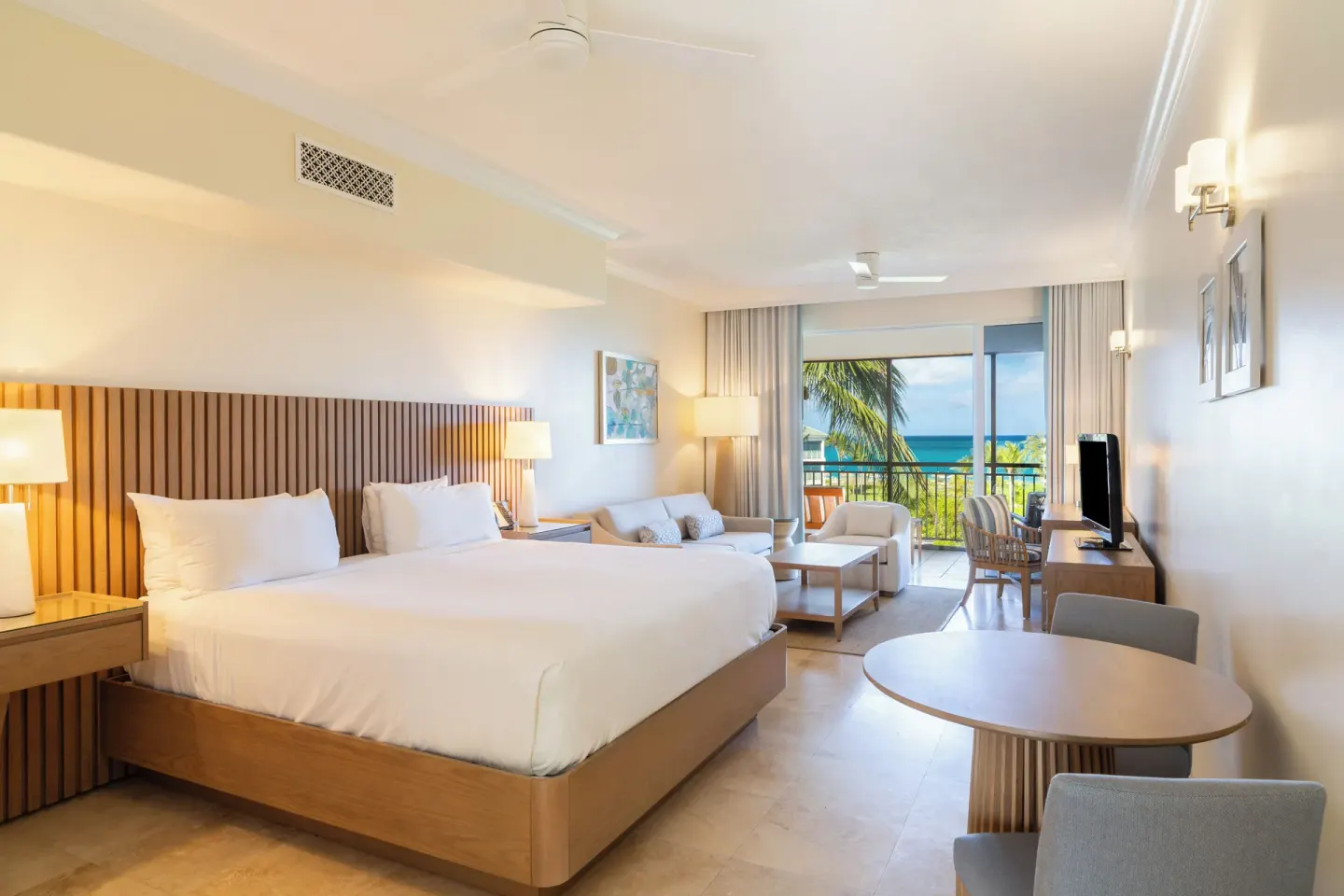 Junior Suite ocean view room with king bed and balcony at The Sands at Grace Bay.
