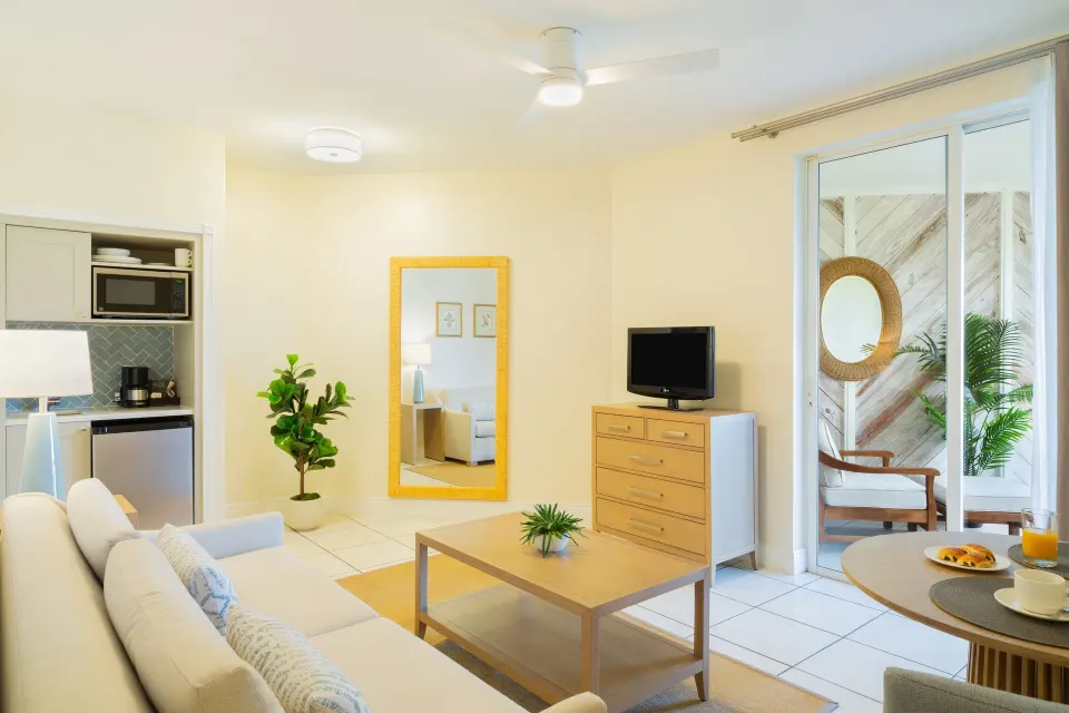 Junior Suite sitting area with kitchenette and patio doors at The Sands at Grace Bay.
