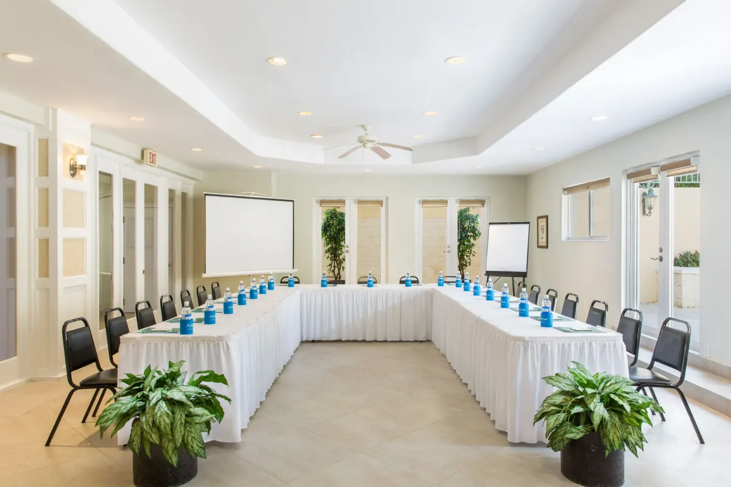 A U-shaped conference table setup fills a bright meeting room at The Sands at Grace Bay.