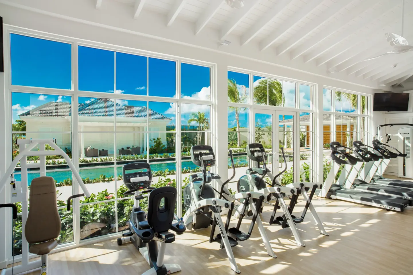 Fitness room with cardio machines and large windows at The Shore Club Turks and Caicos.