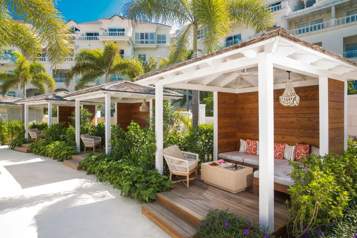 Garden cabanas with cushioned seating and palms at The Shore Club Turks and Caicos.