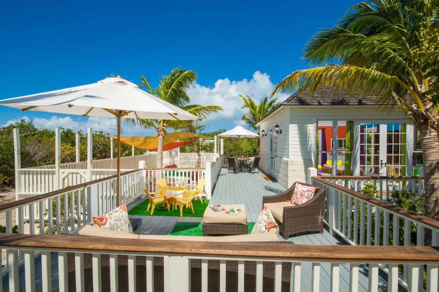 Outdoor kids club deck with umbrellas and seating at The Shore Club Turks and Caicos.