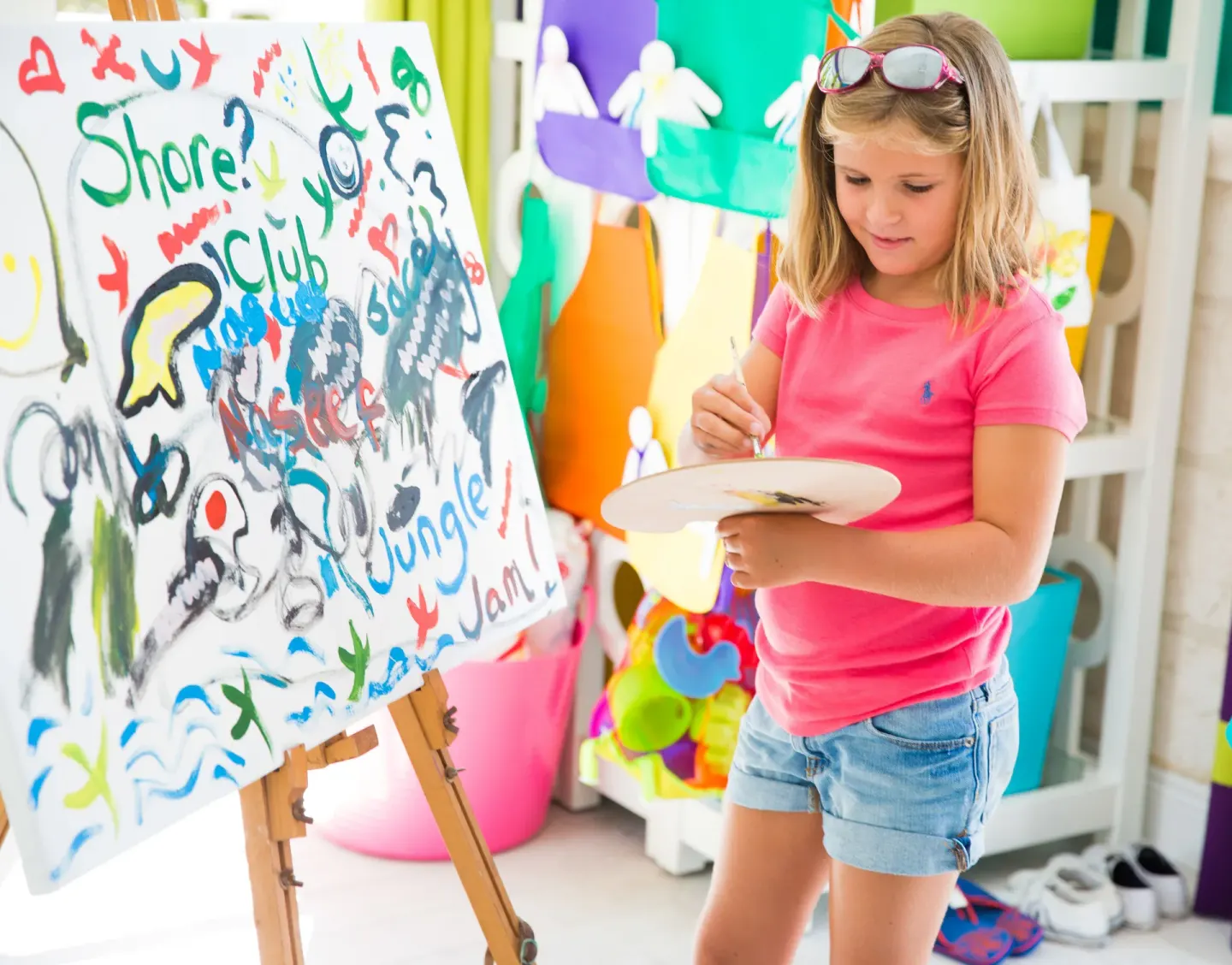 A child paints at a colorful kids club easel at The Shore Club Turks and Caicos.