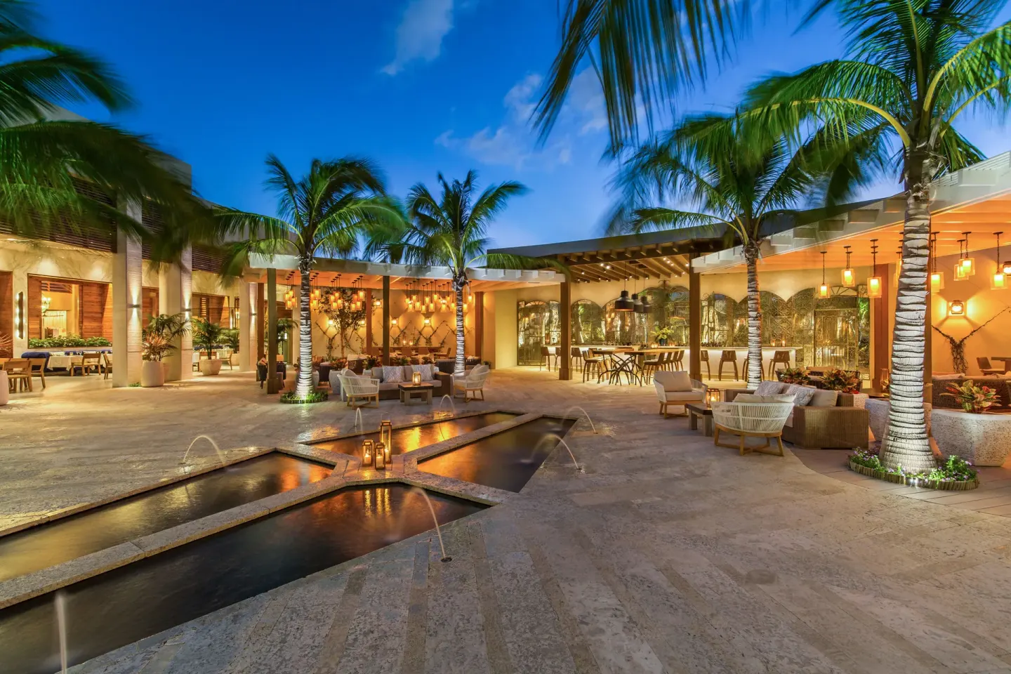 Palm-lined evening courtyard with fountains at The Shore Club Turks and Caicos.