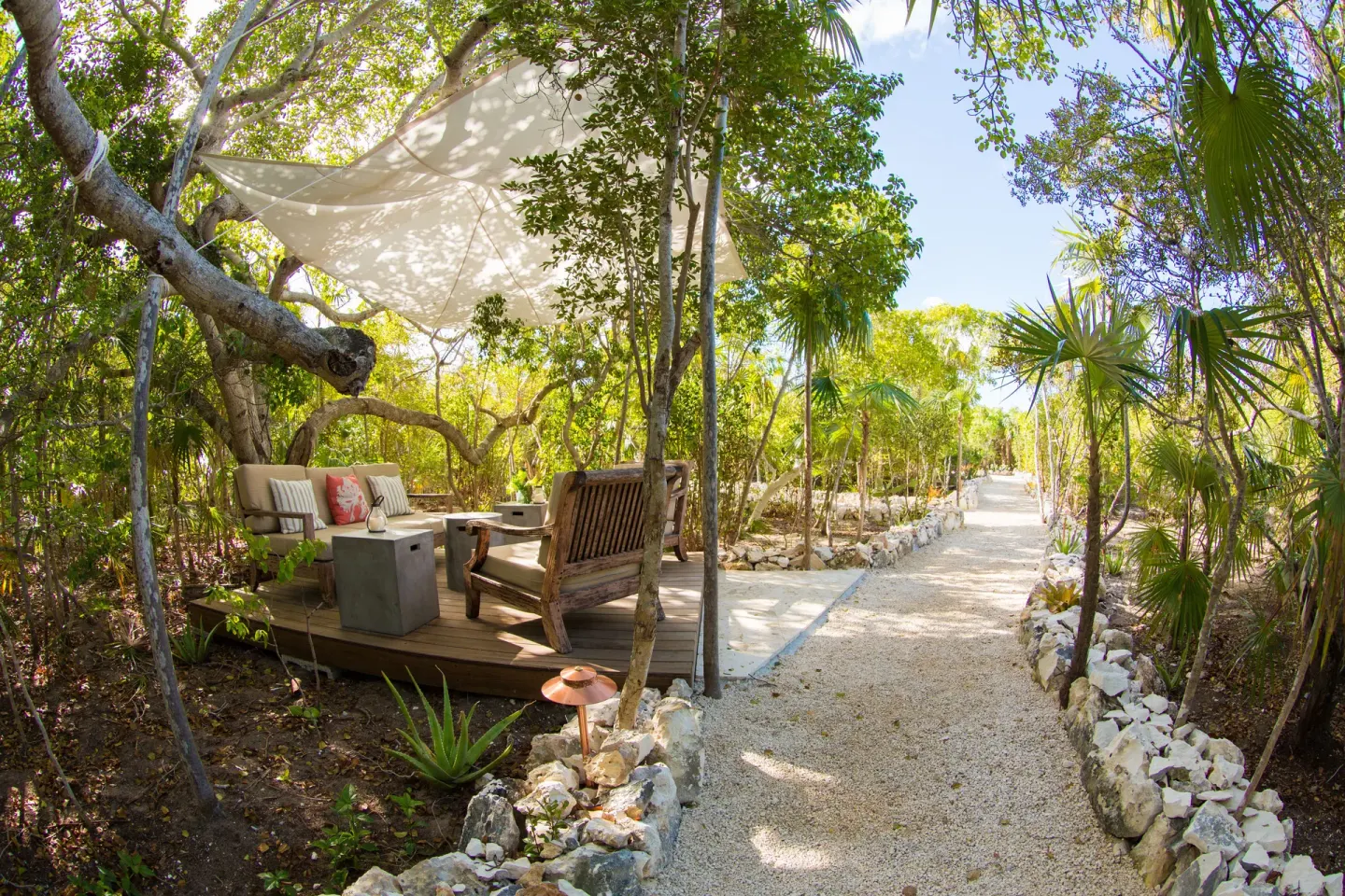 Shaded garden seating beside a gravel path at The Shore Club Turks and Caicos.