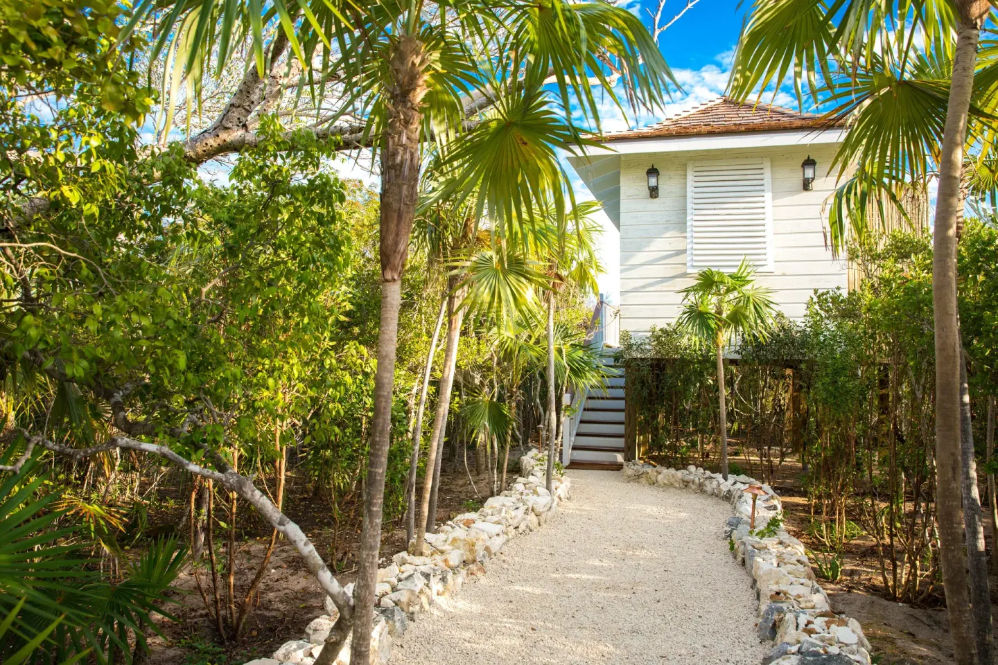 Tropical garden path leading to a white building at The Shore Club Turks and Caicos.