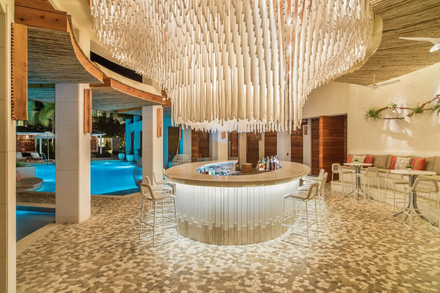 Curved illuminated bar beneath a sculptural ceiling feature at The Shore Club Turks and Caicos.