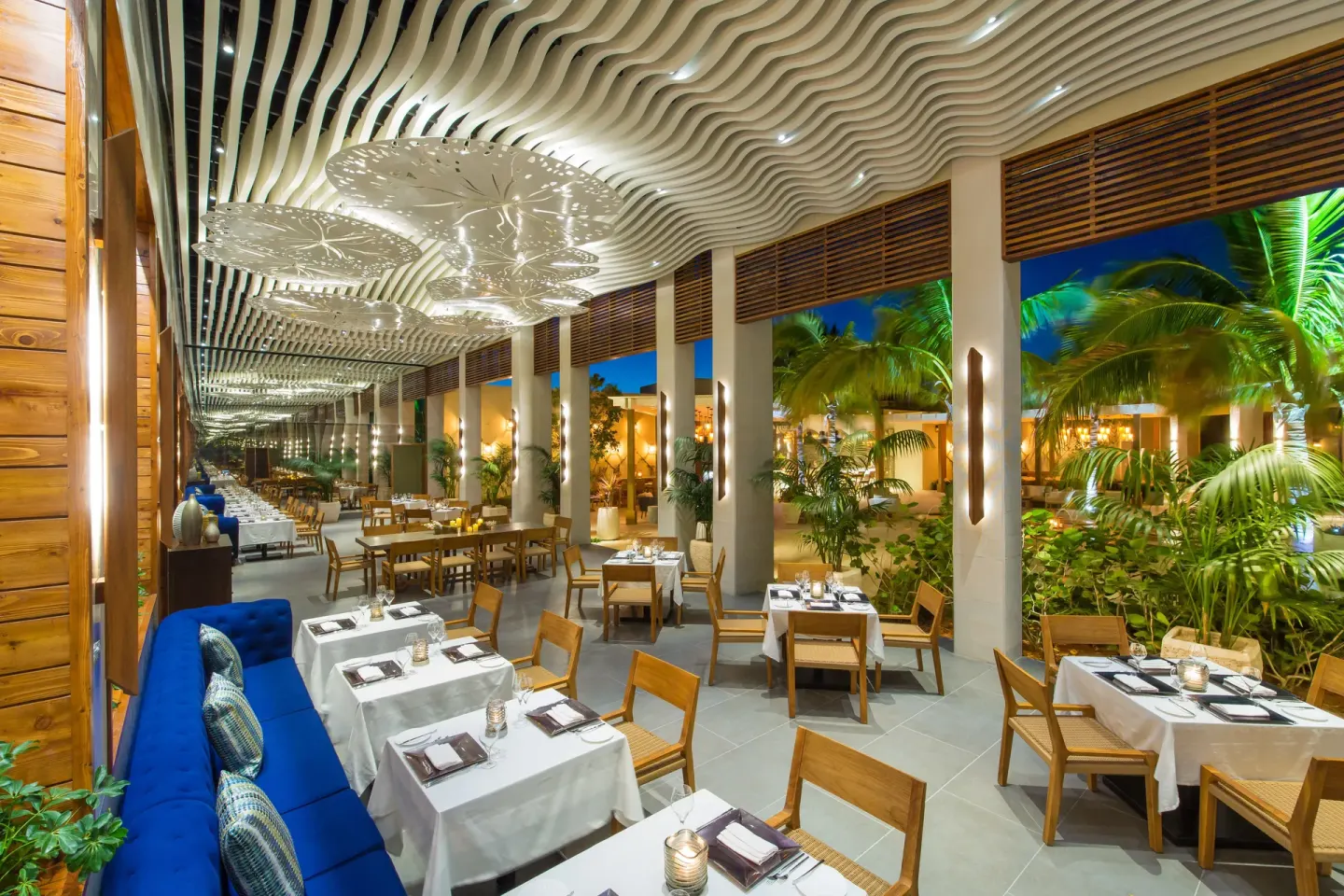 Open-air restaurant tables beside tropical landscaping at The Shore Club Turks and Caicos.