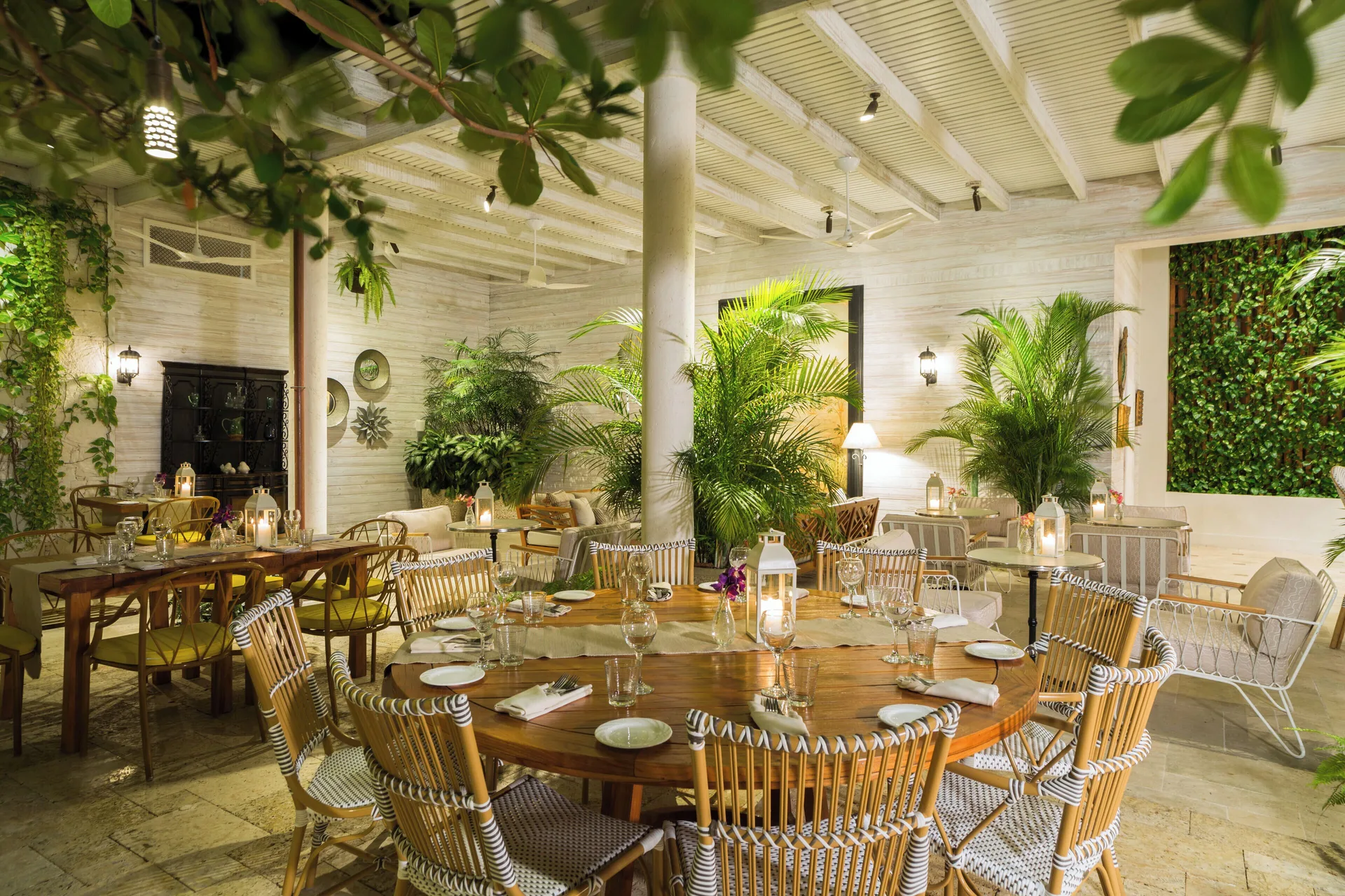 Lantern-lit dining tables surrounded by tropical plants at The Shore Club Turks and Caicos.