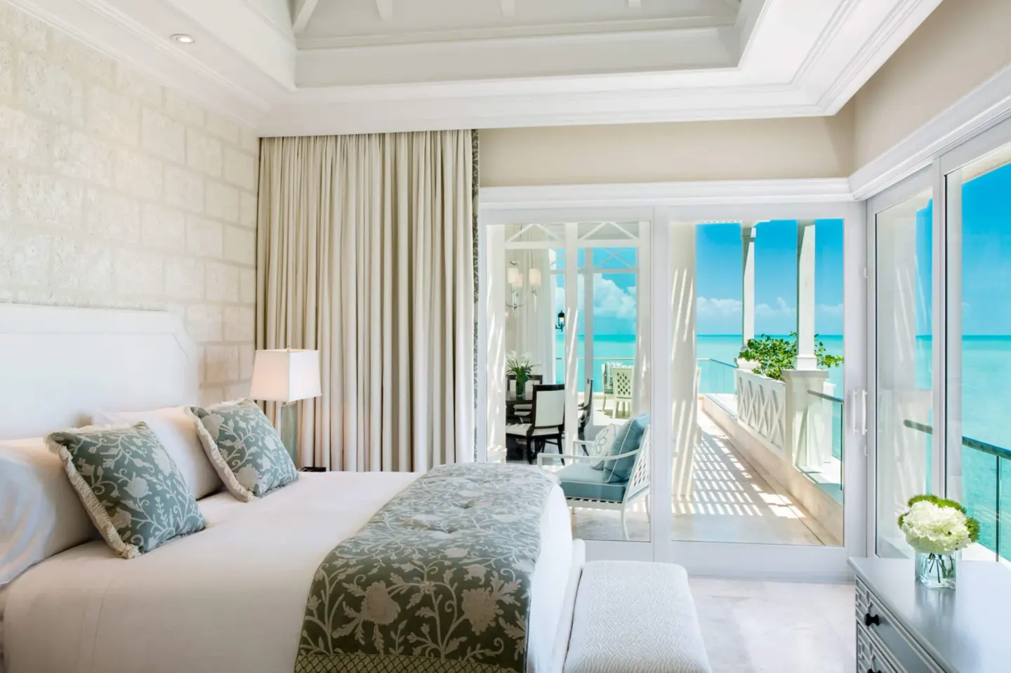 Oceanfront bedroom with bed, balcony, and sea view at The Shore Club Turks and Caicos.