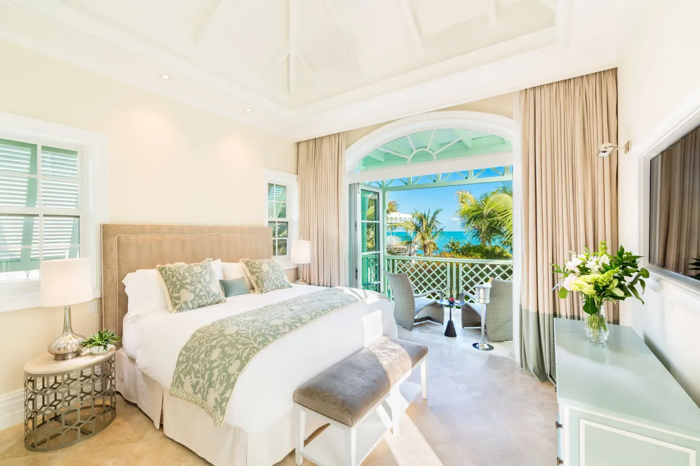 King bedroom in a Luxury Villa at The Shore Club Turks and Caicos opening to an ocean-facing balcony.
