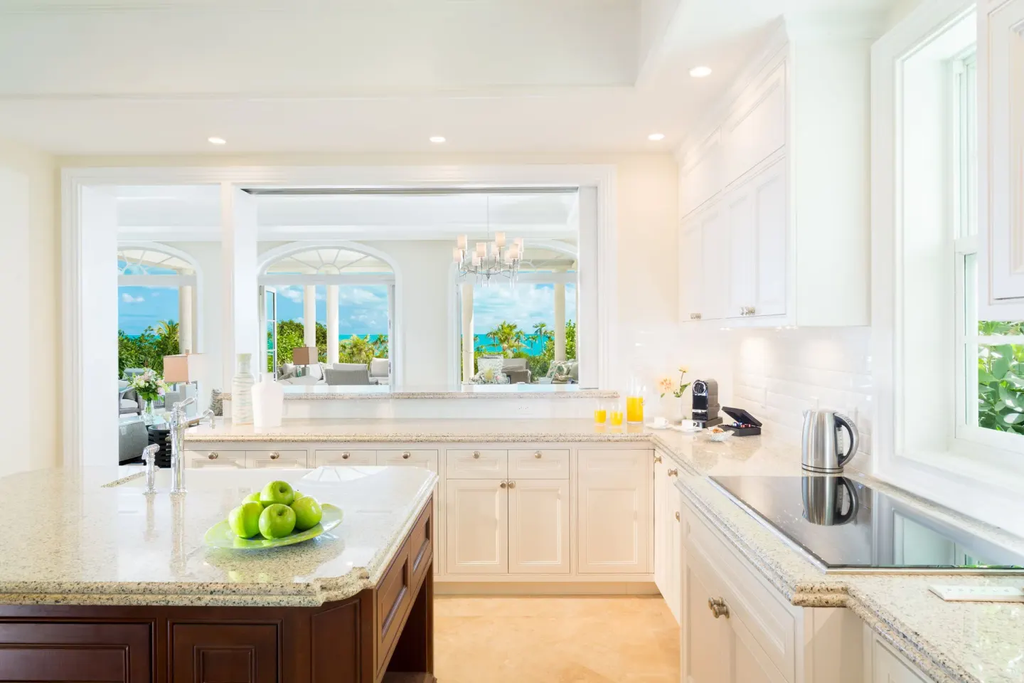 Luxury Villa kitchen at The Shore Club Turks and Caicos with granite counters and ocean views beyond.