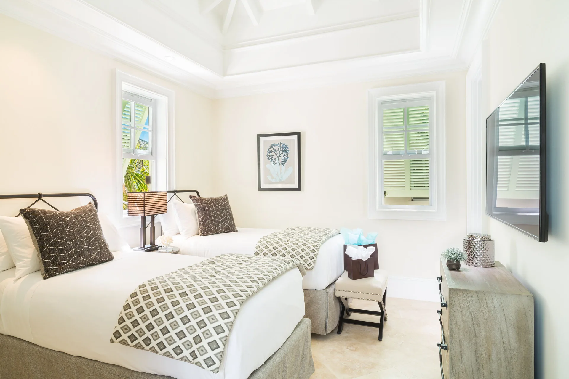 Twin bedroom in a Luxury Villa at The Shore Club Turks and Caicos with shuttered windows and wall TV.