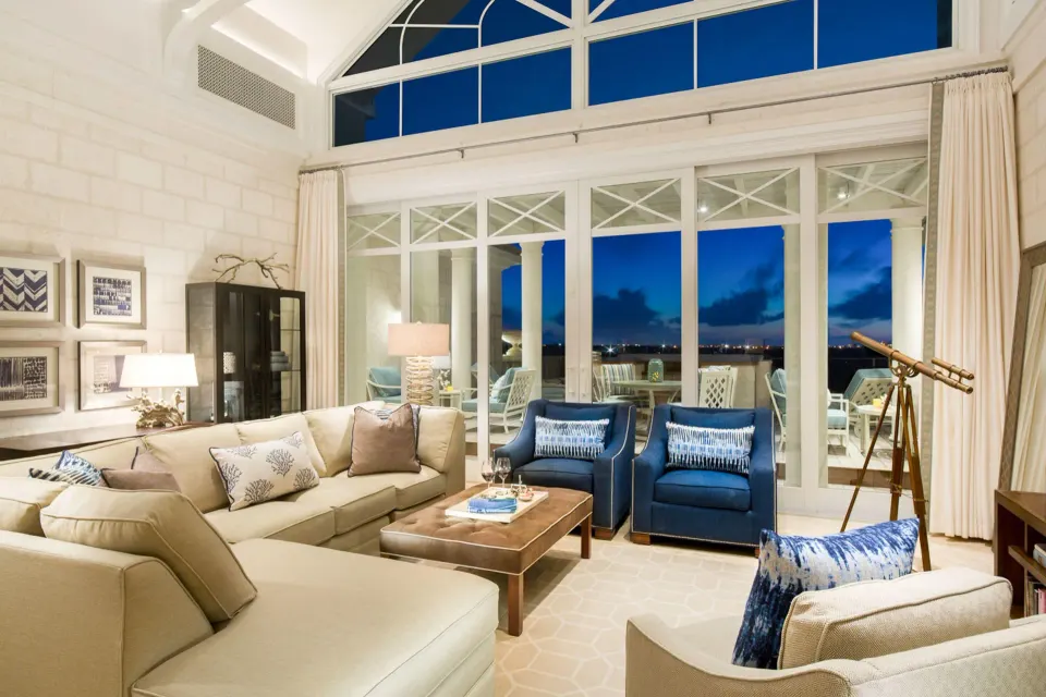 Penthouse living room with blue armchairs and terrace at night at The Shore Club Turks and Caicos.