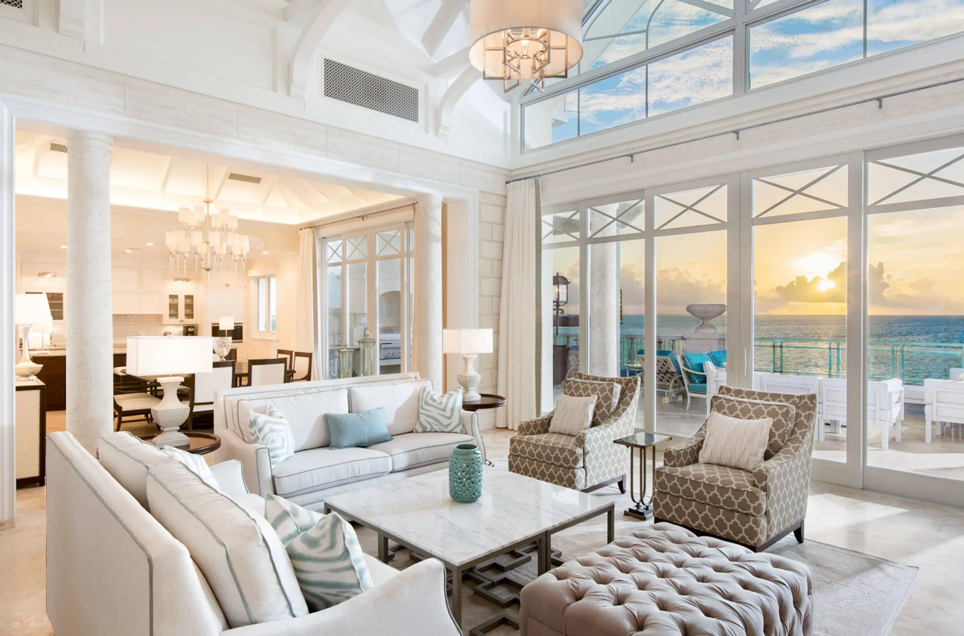 Penthouse living room with terrace doors and sunset ocean view at The Shore Club Turks and Caicos.